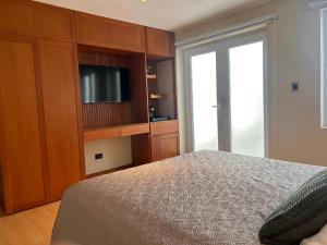 una camera con letto e TV in un armadio di Habitación privada con baño a Lima