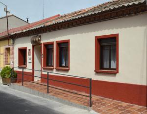 a building with red windows on a street at Casa Rural Las Barricas in Coca