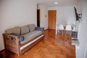 sala de estar con sofá y suelo de madera en Departamento en Obispo Trejo by Lofty en Córdoba