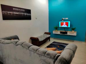 uma sala de estar com um sofá e uma televisão em SALAM Homestay D'Gerik em Gerik