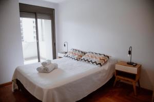 Un dormitorio con una cama blanca con toallas. en Departamento en Obispo Trejo by Lofty en Córdoba