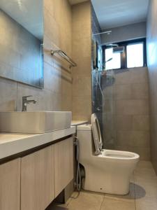 The Shore KK City Sabah Homestay في كوتا كينابالو: حمام مع مرحاض ومغسلة ودش