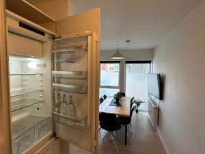 a kitchen with a refrigerator and a table in it at Central Apartment with Panorama Rooftop & Free Parking in Aarhus