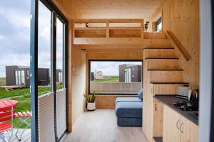 a tiny house with a kitchen and a living room at Tiny House Nature 5 Innenlage - Green Tiny Village Harlesiel in Carolinensiel