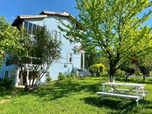 un banc blanc dans l'herbe devant une maison dans l'établissement Maşukiye Home Suit Apart, à Kartepe