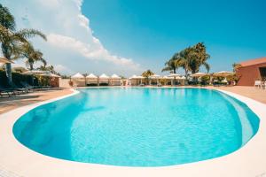 ein großer Pool mit blauem Wasser in einem Resort in der Unterkunft Albatros Hotel in Syrakus