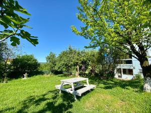 une table de pique-nique assise dans l'herbe à côté d'un arbre dans l'établissement Maşukiye Home Suit Apart, à Kartepe