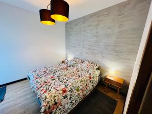 1 dormitorio con 1 cama y 1 mesa con 2 luces en Apartament Morsa w Nautica Resort, en Giżycko