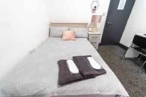 a bedroom with a bed with towels on it at Spacious studio near city centre! in Birmingham