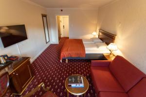 pokój hotelowy z łóżkiem i kanapą w obiekcie Fleischer's Hotel w Vossevangen