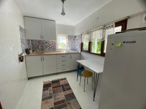 a kitchen with a refrigerator and a table in it at Maşukiye Home Suit Apart in Kartepe