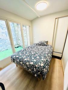 - une chambre dotée d'un lit avec une couette à fleurs et de fenêtres dans l'établissement The Cocoon in the center of Senlis, à Senlis