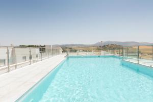 una grande piscina con acqua blu su un edificio di Apartamentos Martalia Áticos Deluxe a Ronda