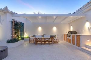 a patio with a table and chairs and a kitchen at Koroneia Residence in Koroni