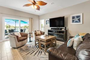 a living room with a couch and a tv at Beachy Dreams in Pensacola Beach