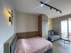 1 dormitorio con 1 cama grande y 1 sofá en Bellavista apartment, en Durrës