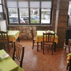 un restaurante con 2 mesas, sillas y ventanas en B&B Feral, en Rovinj