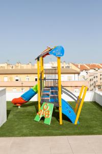 un parque infantil con 2 toboganes en el césped en Apartamentos Martalia Áticos Deluxe, en Ronda