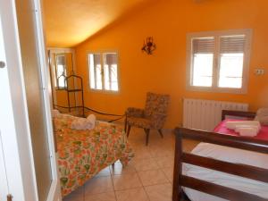 1 dormitorio con paredes de color naranja, 1 cama y 1 silla en Casale Grandangolo en Capoliveri