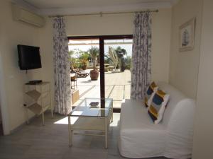 a living room with a white couch and a glass table at Home4Holidays in Nerja