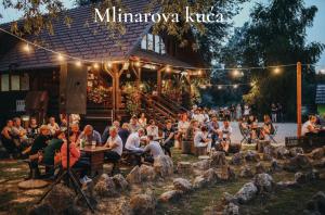 een menigte mensen die aan tafels voor een gebouw zitten bij Holiday Home Lu in Grkavešćak