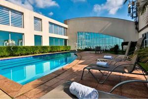 a swimming pool in front of a building at Flat BOUTIQUE em frente ao metrô MOEMA in Sao Paulo