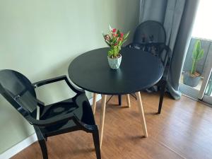 a black table with a vase of flowers on it at Flat BOUTIQUE em frente ao metrô MOEMA in Sao Paulo