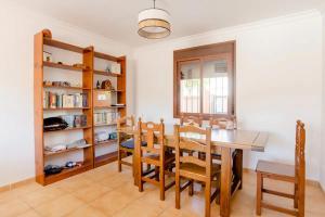 a dining room with a table and chairs and bookshelves at Habitación en Casa Vacacional Fuengirola in Fuengirola