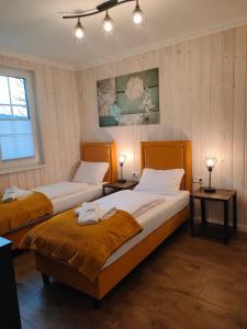 2 Betten in einem Zimmer mit 2 Tischen und 2 Lampen in der Unterkunft Karkonoskie Zacisze pod Śnieżką in Miłków