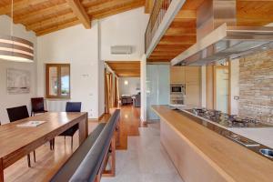 eine Küche und ein Esszimmer mit einem langen Holztisch in der Unterkunft Villa Sellemond in Lazise