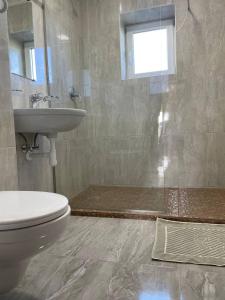 La salle de bains est pourvue de toilettes et d'un lavabo. dans l'établissement Yellow apartments, à Boryspil