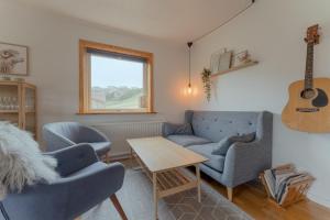 a living room with two chairs and a guitar at Unique Location - Bodanes - Hoydalar - 6 BR Villa in Tórshavn