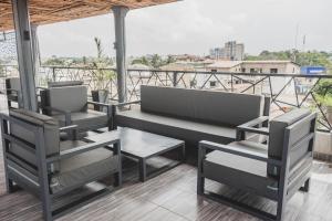 2 Stühle und eine Bank auf dem Balkon in der Unterkunft les perles du bonheur Nyékonakpoé in Lomé
