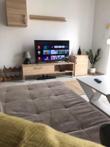 salon z telewizorem z płaskim ekranem i kanapą w obiekcie Lefkothea's central apartment w Salonikach