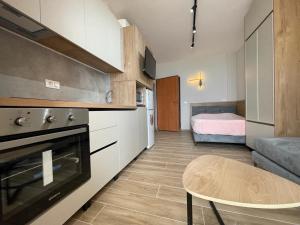 a kitchen with a table and a room with a bed at Bellavista apartment in Durrës