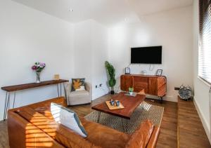 a living room with a couch and a flat screen tv at Beautiful Three Bed Flat in Nottingham City Centre in Nottingham