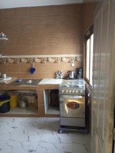 a small kitchen with a stove and a sink at Mamou hlm grang yoff in Dakar