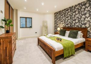 a large bedroom with a large bed and a dresser at Beautiful Three Bed Flat in Nottingham City Centre in Nottingham