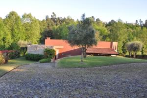 una casa con un árbol y una entrada de grava en Casa de Outeiro en Cabeceiras de Basto