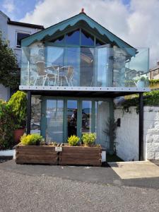een glazen huis met een tafel en stoelen bovenop bij The Old Boat House in Carlingford