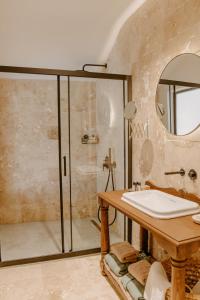 a bathroom with a shower and a sink and a mirror at Çiy Restaurant & Konukevi in Kusadası