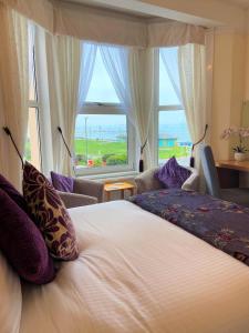 a bedroom with a large bed and a large window at The Briars in Paignton