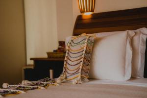Una cama con dos almohadas encima. en Pousada Rangai en Maragogi