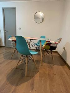 - une table et des chaises dans une pièce avec porte dans l'établissement Departamento en Condominio Parque Francia, à Osorno