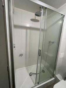y baño con ducha y puerta de cristal. en Departamento en Condominio Parque Francia, en Osorno