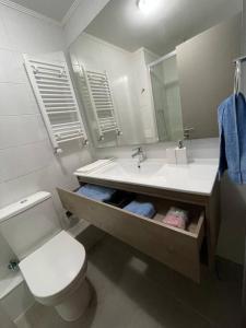 a bathroom with a sink and a toilet and a mirror at Departamento en Condominio Parque Francia in Osorno