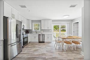 a kitchen with white cabinets and a table and chairs at 30A Pet Friendly Beach House - Vitamin Sea by Panhandle Getaways in Santa Rosa Beach