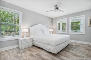 a white bedroom with a bed and two windows at 30A Pet Friendly Beach House - Vitamin Sea by Panhandle Getaways in Santa Rosa Beach