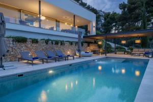 a house with a swimming pool and patio furniture at Villa Marvelo in El Port