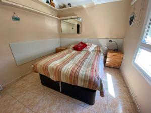 a bedroom with a bed with a red pillow on it at Espectacular apartament a Palamós centre! Amb WIFI in Palamós